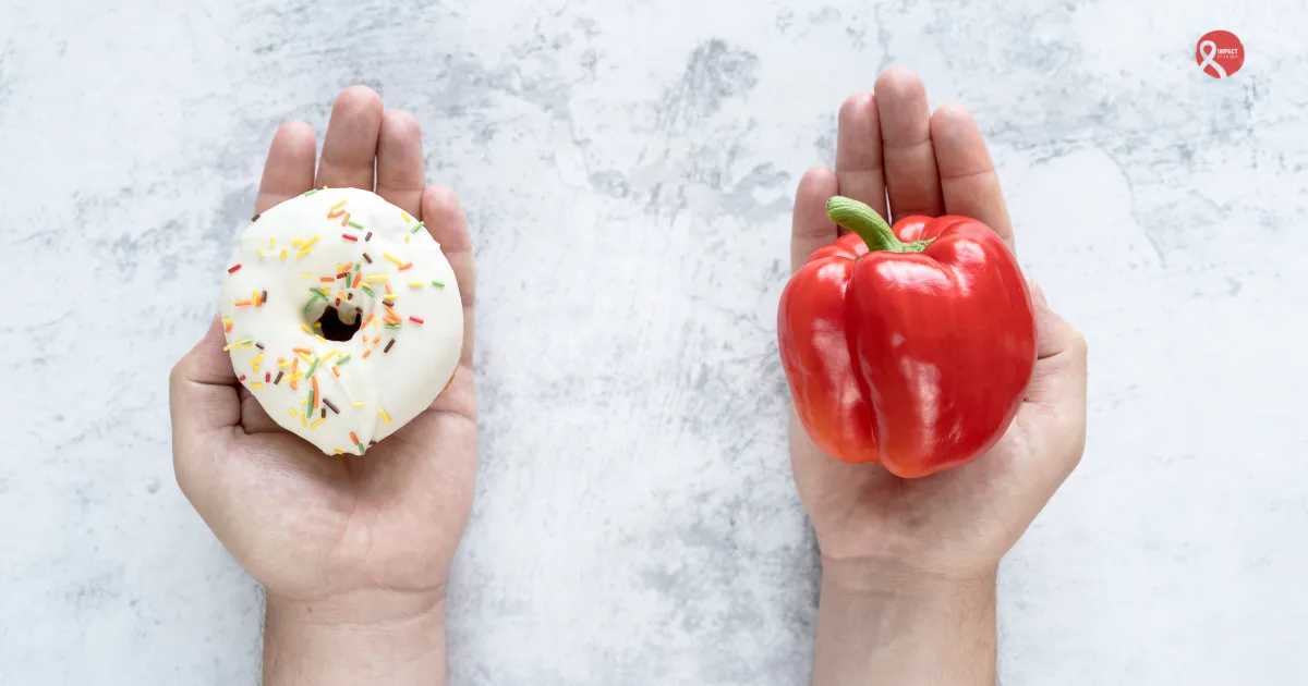 Two hands holding different foods- one with a white frosted donut and the other with a fresh red bell pepper-illustrating the choice between unhealthy and healthy food options for cancer patients.