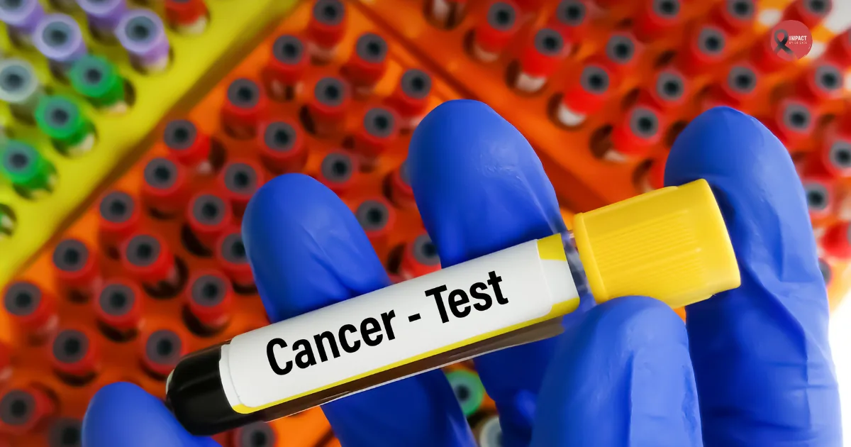 A gloved hand holding a blood sample tube labeled “Cancer Test,” with rows of colorful test tubes in the background, representing laboratory testing for cancer diagnosis at affordable rates.