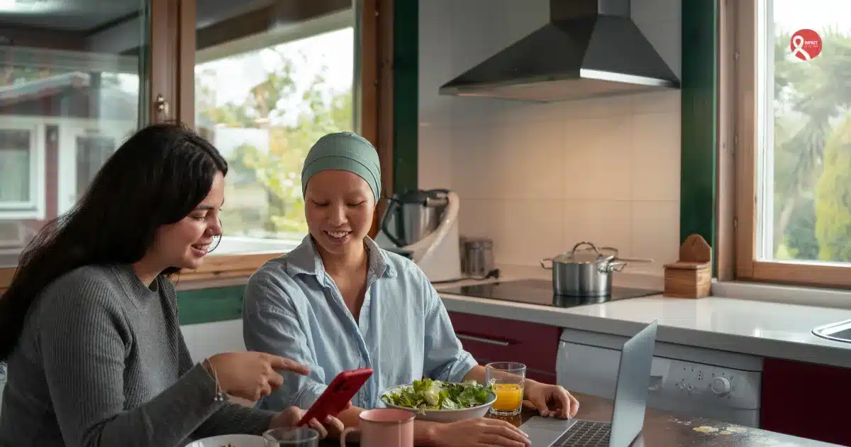 Two women sharing a healthy meal at home, showing supportive companionship during cancer recovery.